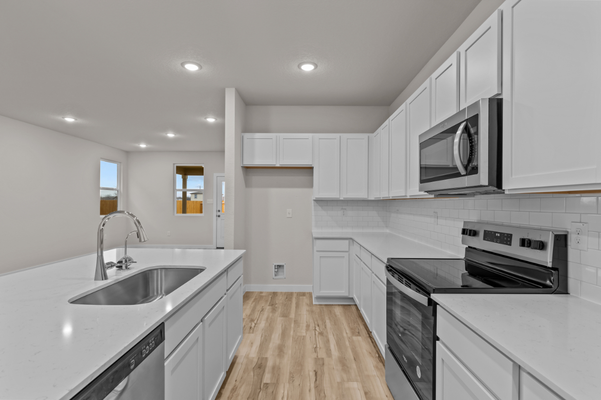 A kitchen with white cabinets.