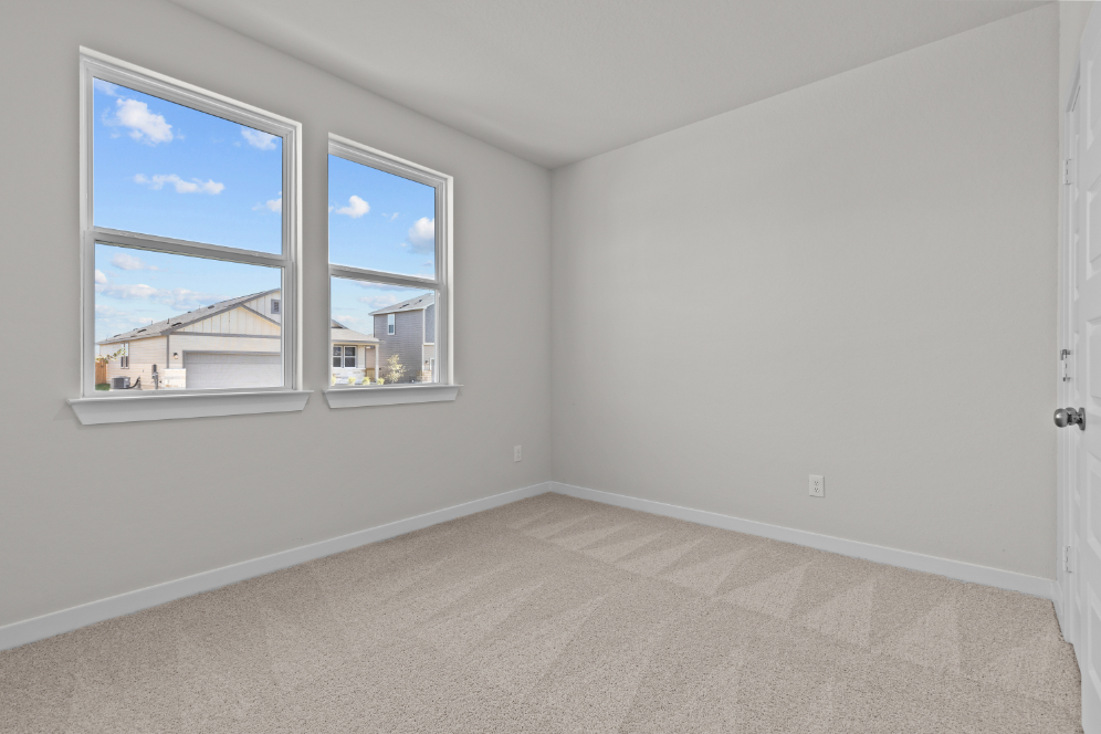 A room with a window and a carpet.