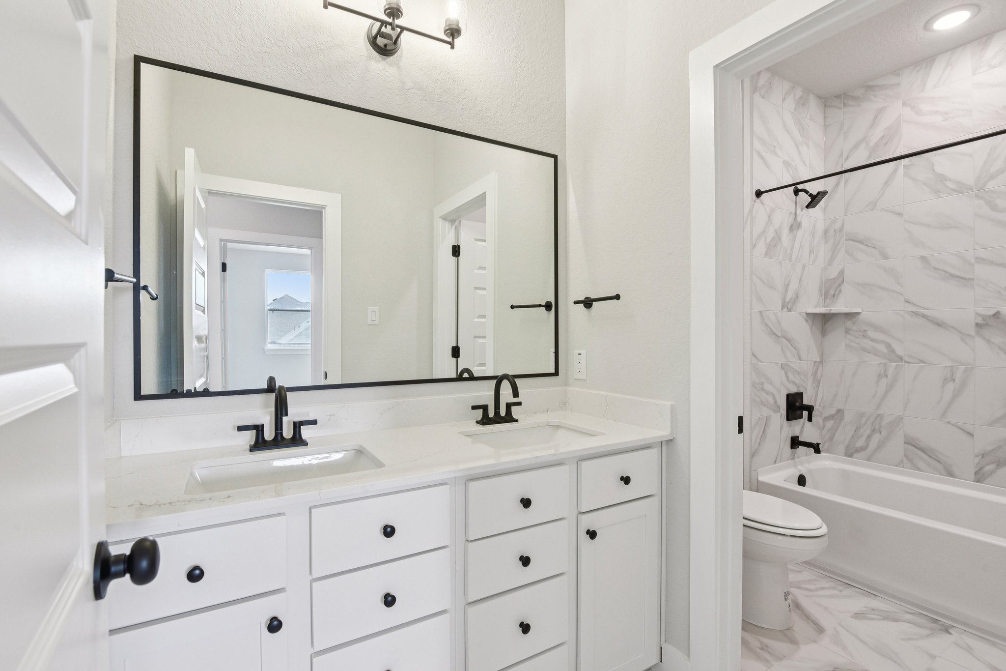 A bathroom with a tub sink and toilet.