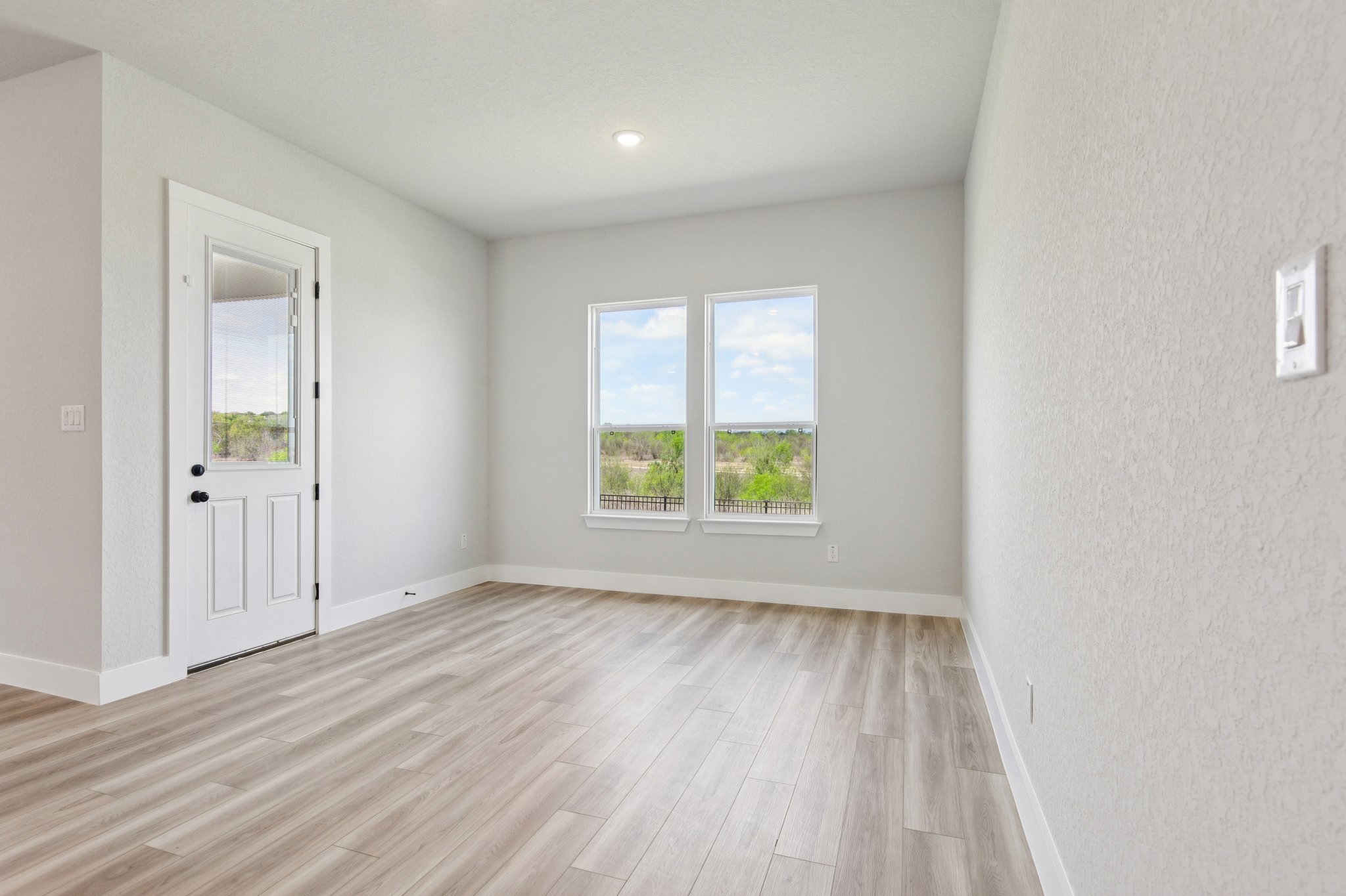 A room with a wood floor and a wood floor with a door.