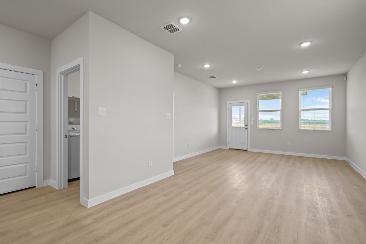 A room with white walls and wood floors.