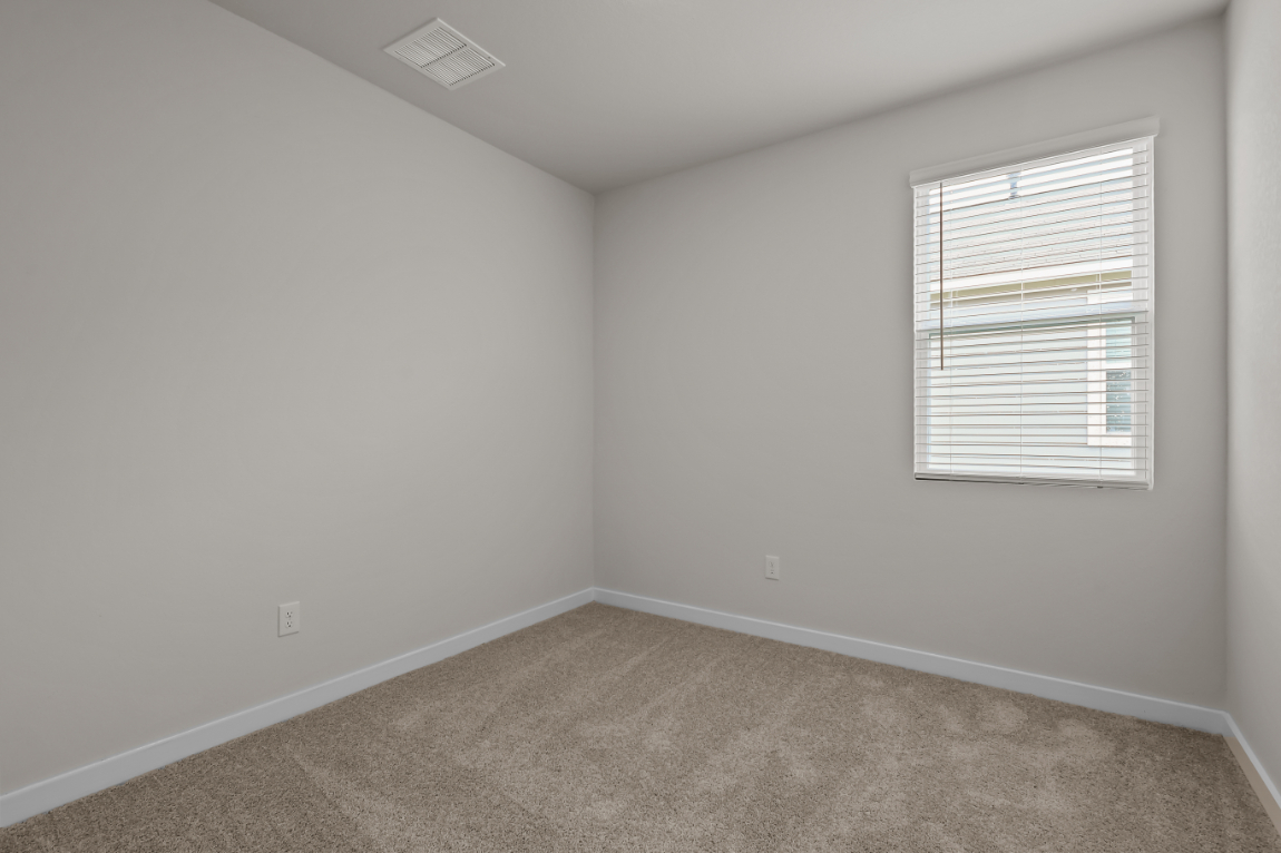 A room with a carpet and a window.
