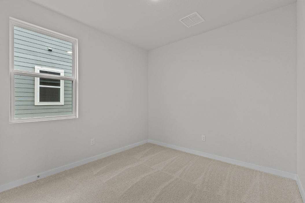 A room with a window and a rug.