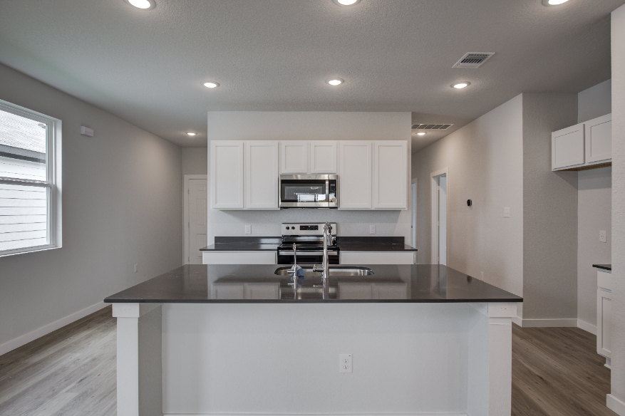 A kitchen with white cabinets.