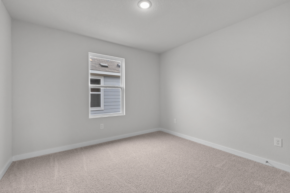 A room with a window and a carpet.