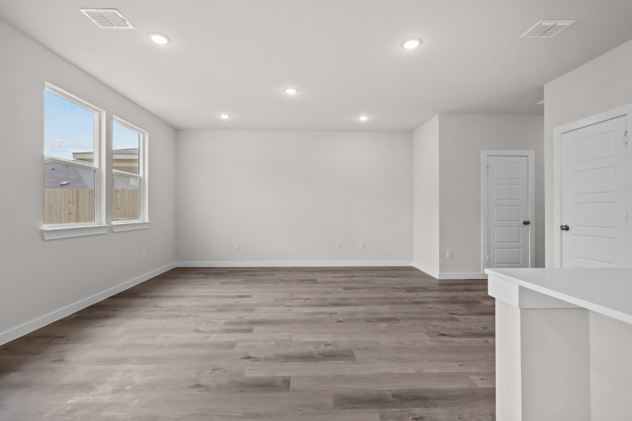 A room with white walls and wood floors.
