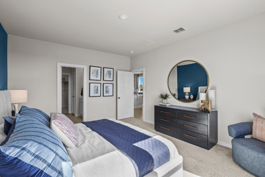 A bedroom with a bed and a mirror.