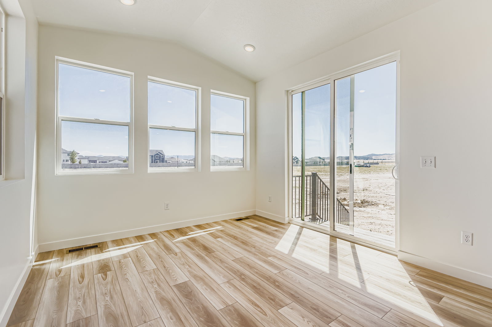 A room with windows and a wood floor.