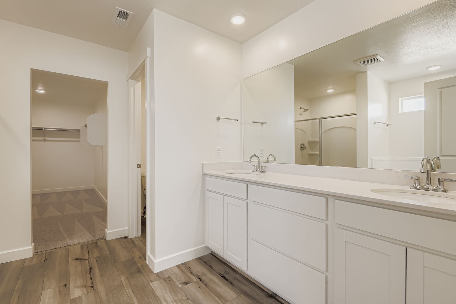A bathroom with white cabinets.