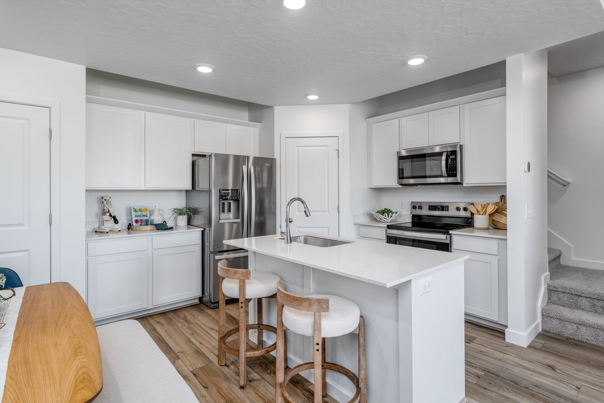 A kitchen with white cabinets.