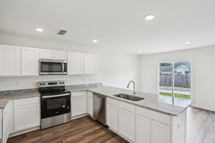 A kitchen with white cabinets.