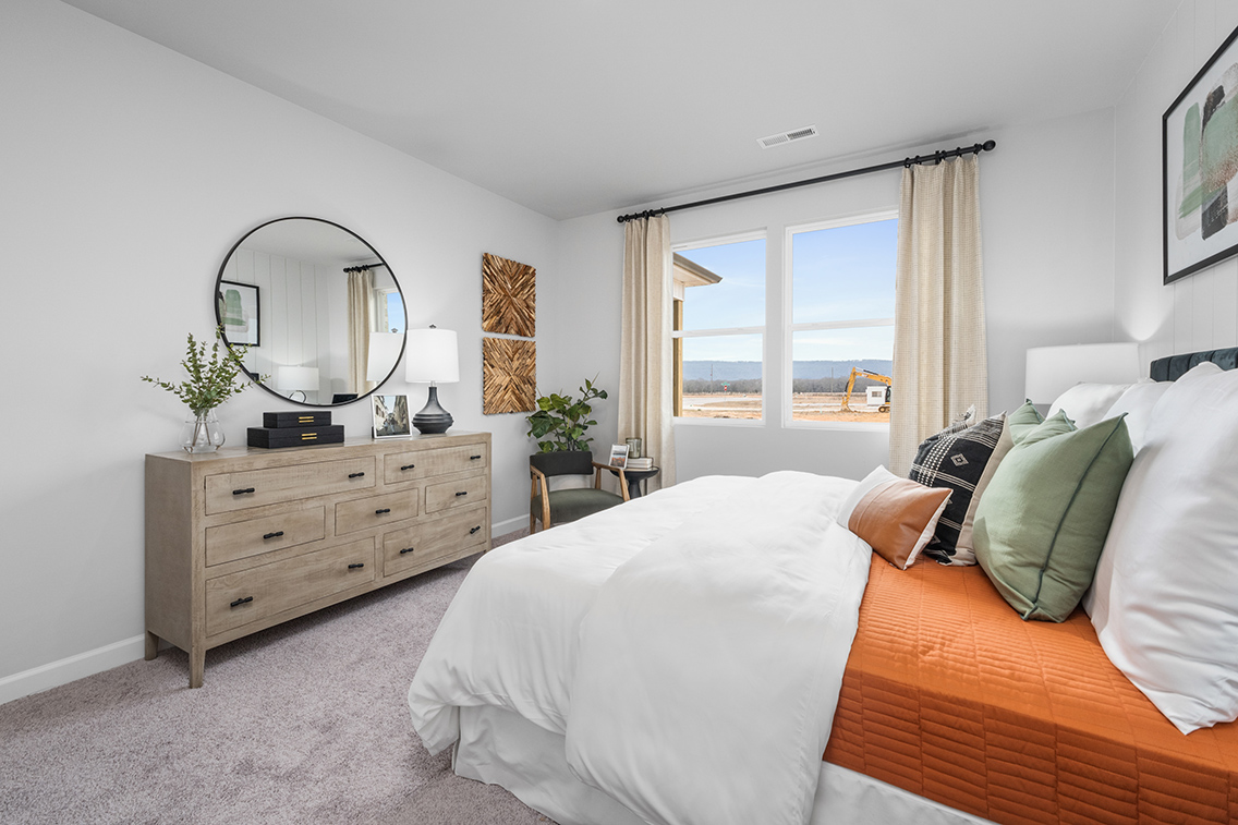 A bedroom with a large window.