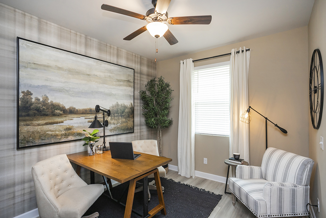A living room with a fan and a table.