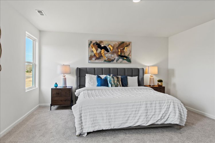 A bedroom with a bed and lamps.