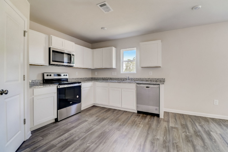 A kitchen with white cabinets.